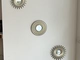 three mirrors mounted on the wall of a living room