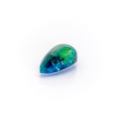 a green and blue oplite stone on a white surface
