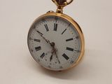 une petite montre de poche en or avec des chiffres romains