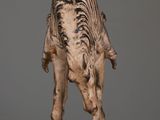 statue of a zebra standing on a wooden table with a gray background