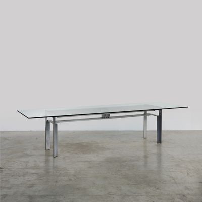 une table en verre avec des pieds en métal et un plateau en verre