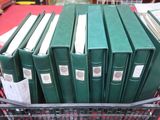 de nombreux livres verts dans un panier posé sur une table