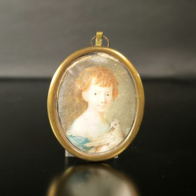 une petite image représentant une femme en robe bleue posée sur une table