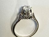 une image d'une bague en diamant sur une surface blanche