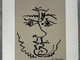 a black and white drawing of a man ' s face on a piece of paper