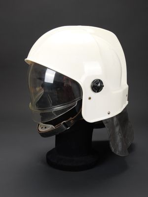 un gros plan d'un casque posé sur un support, sur fond noir
