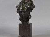 a bronze bust of a woman on a marble base