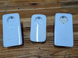 trois télécommandes posées sur une table en bois