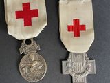 two medals and a medal on a table with a red cross on it