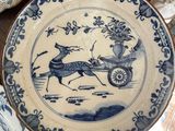 a blue and white plate with a picture of a horse and carriage on it