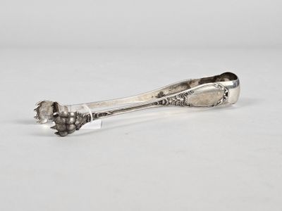 a silver spoon with a flower on it sitting on a white surface