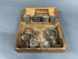 a wooden box filled with assorted silver items