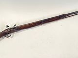 an old rifle with a wooden handle on a white surface