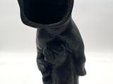 a black vase that has a black hat on top of it