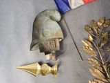 a statue of a man with a hat and a sword next to a flag
