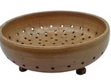 a wooden bowl with holes in it on a white background