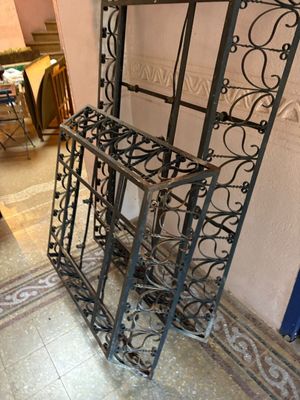 a black iron shelf with a mirror on top of it