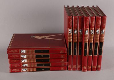 six livres rouges sont empilés les uns sur les autres sur une surface blanche