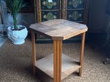 a small wooden table with a shelf in the middle of the room