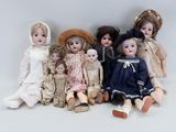 many dolls that are lined up together on the floor