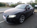 black audi s8 parked in a parking lot next to a green fence