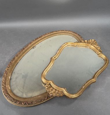 pair of antique gold framed mirrors on a gray surface