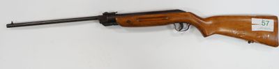 rifle mounted on a wall in a room with a white wall