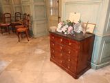 a dresser with flowers on top of it in the middle of a room
