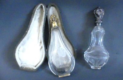 deux cuillères en argent et une bouteille en verre posées sur un fond bleu