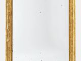une image d'un miroir encadré d'or sur un mur blanc