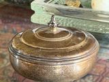 a glass bowl with a lid sitting on a glass table