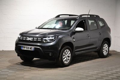 La Dacia grise est garée dans le garage, sur un sol à damier.