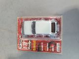 a white toy car in a package on a table