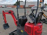 a small red excavator that is parked in the parking lot