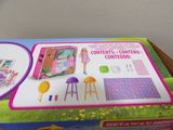 a box with a doll and a doll house inside of it