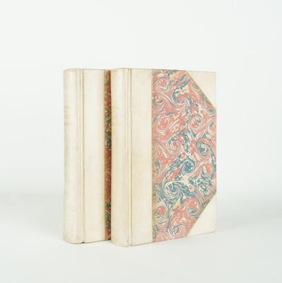 two books are stacked on top of each other on a white surface