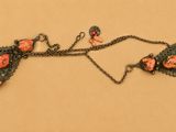 une photo d'un collier orné de fleurs
