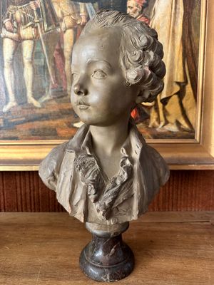 statue of a woman in a dress and a painting in the background