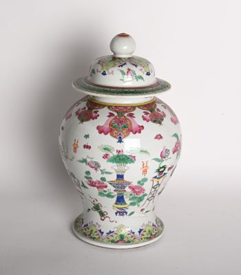 a vase with a lid that has flowers on it