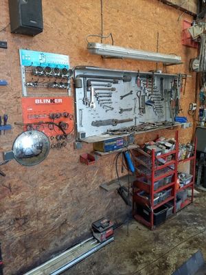 un garage équipé d'un établi et d'outils accrochés au mur