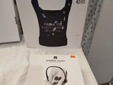 packaging of a white box with a pair of headphones in it on a bed