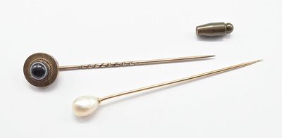 deux épingles et une perle sur un fond blanc