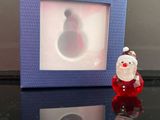 une photo d'une figurine du Père Noël devant un cadre photo