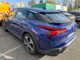 the rear end of a blue car parked in a parking lot