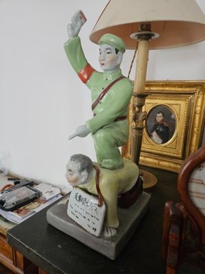 a statue of a man on a table with a lamp on it