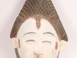 an image of a wooden mask with a hat on it ' s head