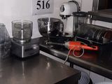 une photo d'une cuisine avec de nombreux ustensiles de cuisine posés sur le plan de travail