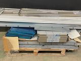 une pile de tôles métalliques posée sur une palette dans un entrepôt