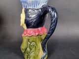 a blue and green vase with a black cat on it