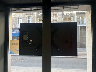 un téléviseur accroché au mur près d'une fenêtre